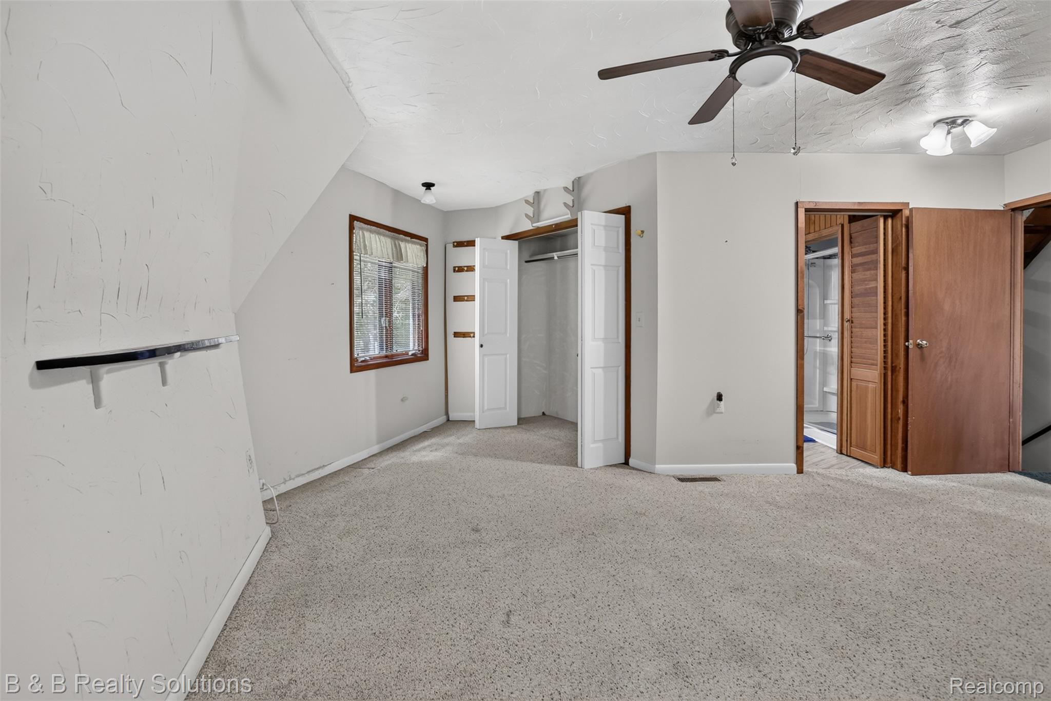 5544 Piersonville Road Columbiaville, MI 48421 - Photo 24 of 49 Carpeted room featuring a ceiling fan with integrated lighting, a window with wood trim, and multiple closets including a louvered bi-fold door