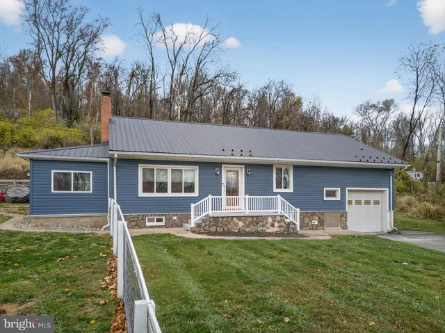 a front view of house with yard and green space