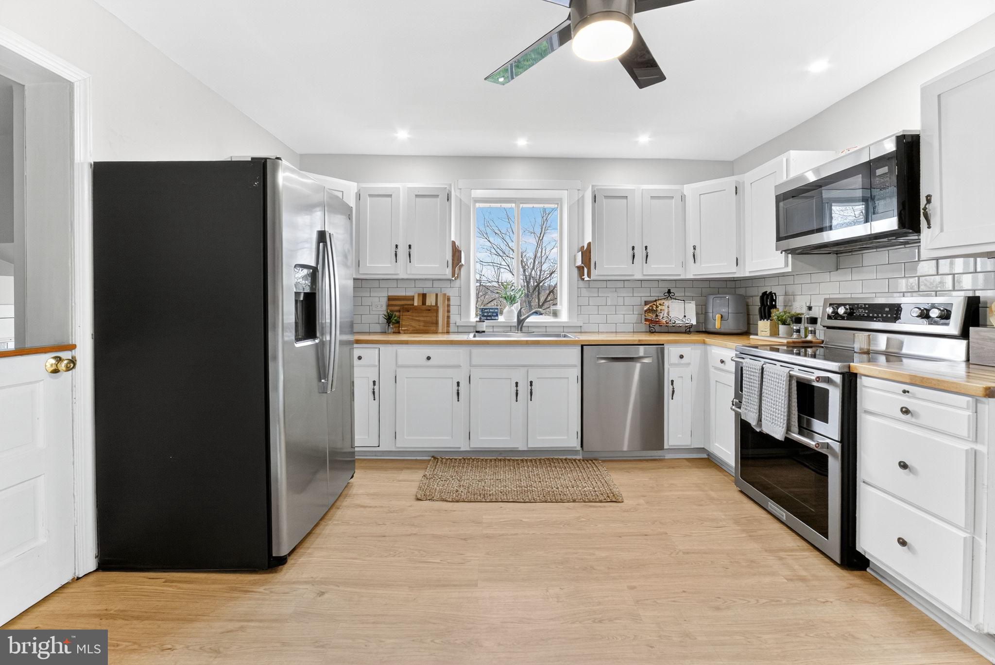 616 Bondsville Road Downingtown, PA 19335 - Photo 17 of 43 a kitchen with stainless steel appliances granite countertop a refrigerator a sink a stove and white cabinets with wooden floor
