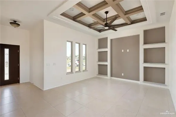 en empty room with windows and ceiling fan