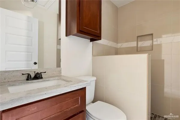 a bathroom with a granite countertop sink a toilet and a mirror