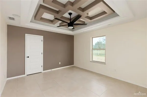 an empty room with windows and fan