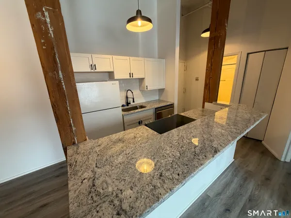 a kitchen with stainless steel appliances granite countertop a sink refrigerator and microwave