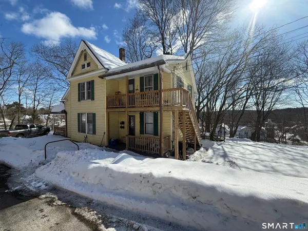a view of a house with a yard covered in snow