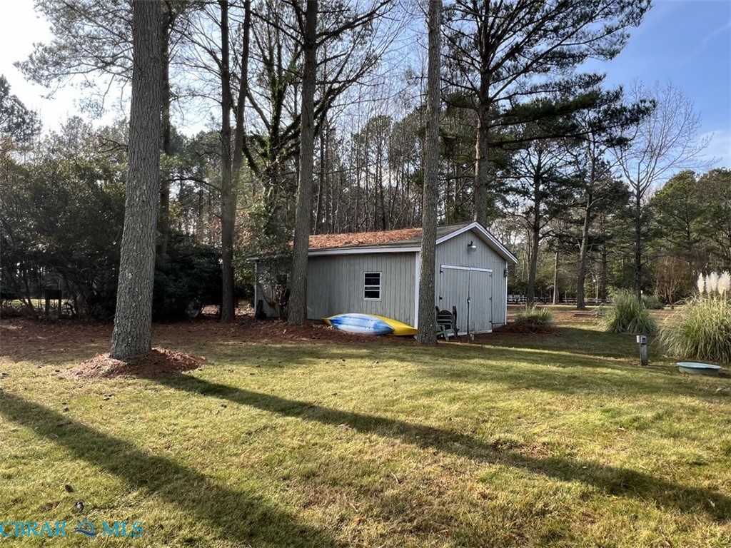 301 Gillim Road Deltaville, VA 23043 - Photo 23 of 31 View of green lawn with an outbuilding and view of wooded area
