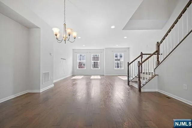 a view of an room with wooden floor chandelier and windows
