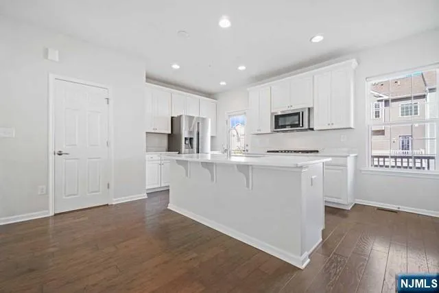 a kitchen with white cabinets and sink