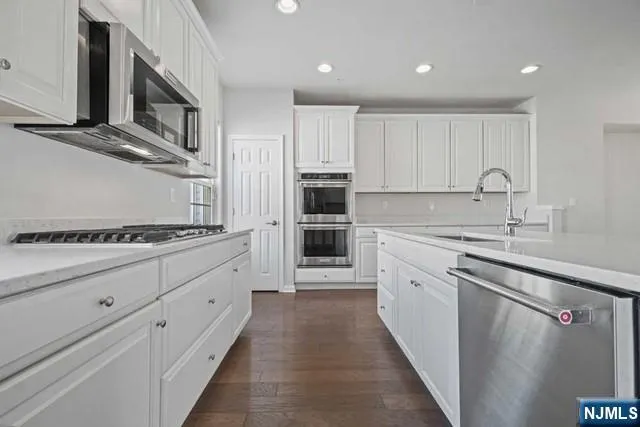 a kitchen with stainless steel appliances granite countertop a stove and a sink