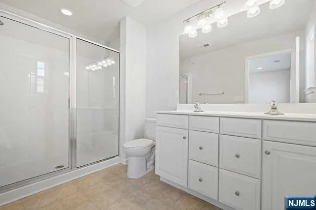 a bathroom with a double vanity sink toilet and shower