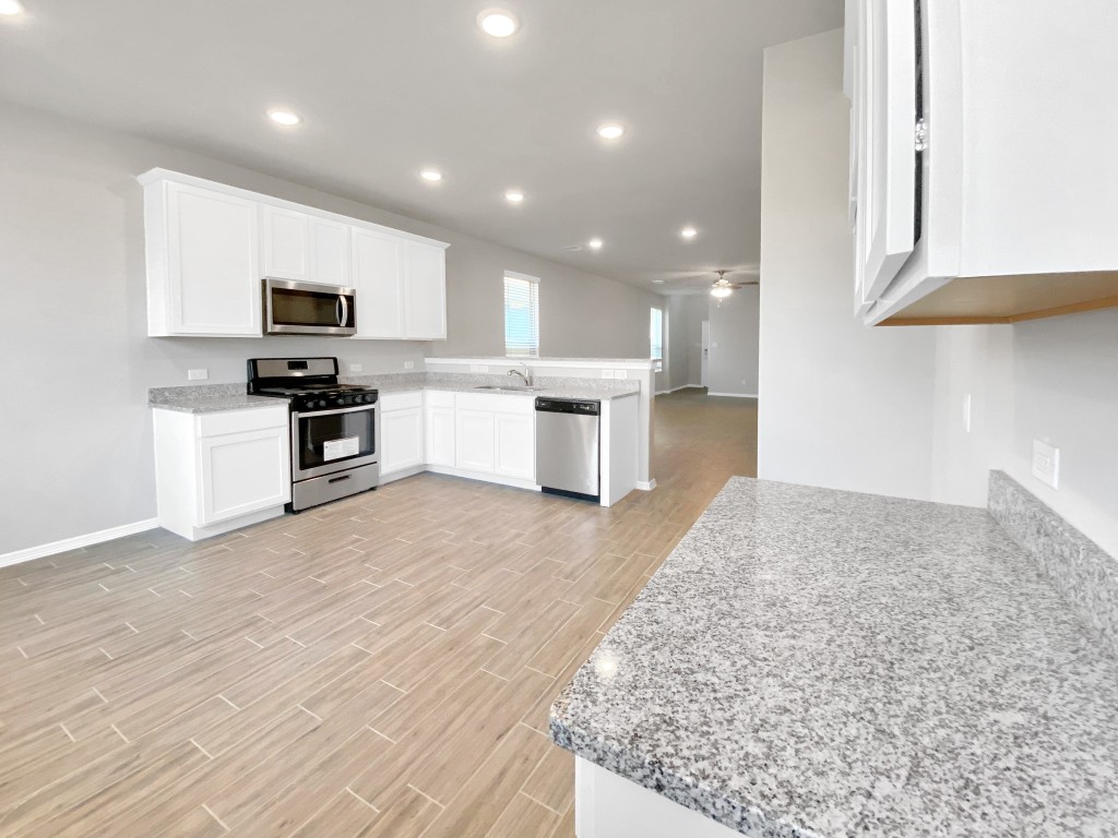 847 Redinger Ridge Drive Huffman, TX 77336 - Photo 8 of 30 a kitchen with a sink stainless steel appliances and cabinets