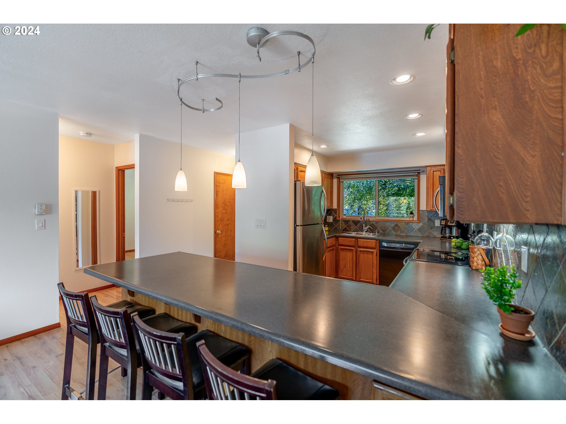 5005 Southwest Mitchell Street, Unit 10 Portland, OR 97221 - Photo 3 of 16 a view of a dining room and livingroom with furniture wooden floor a chandelier