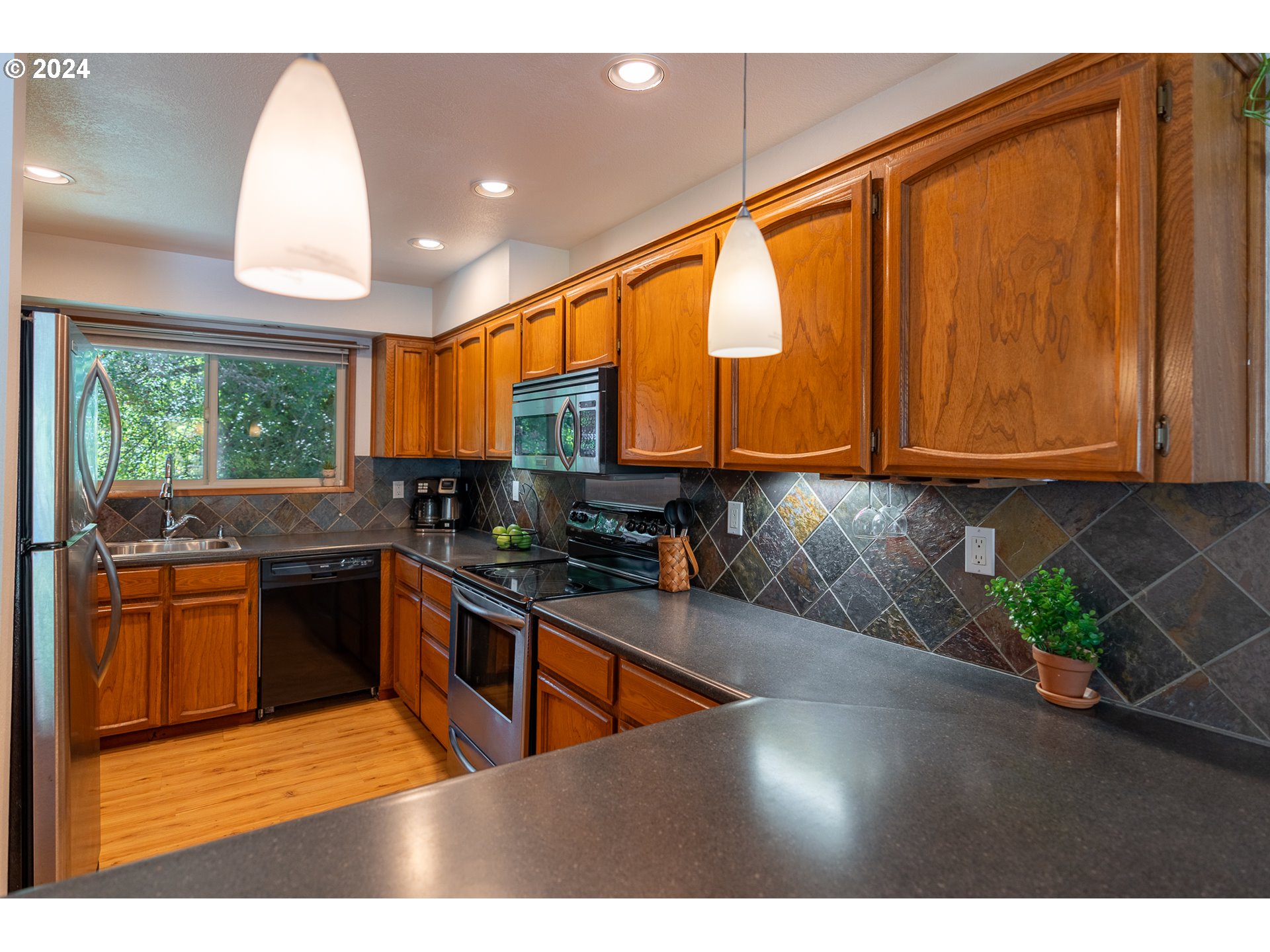 5005 Southwest Mitchell Street, Unit 10 Portland, OR 97221 - Photo 4 of 16 a kitchen with stainless steel appliances granite countertop a stove a sink and a microwave
