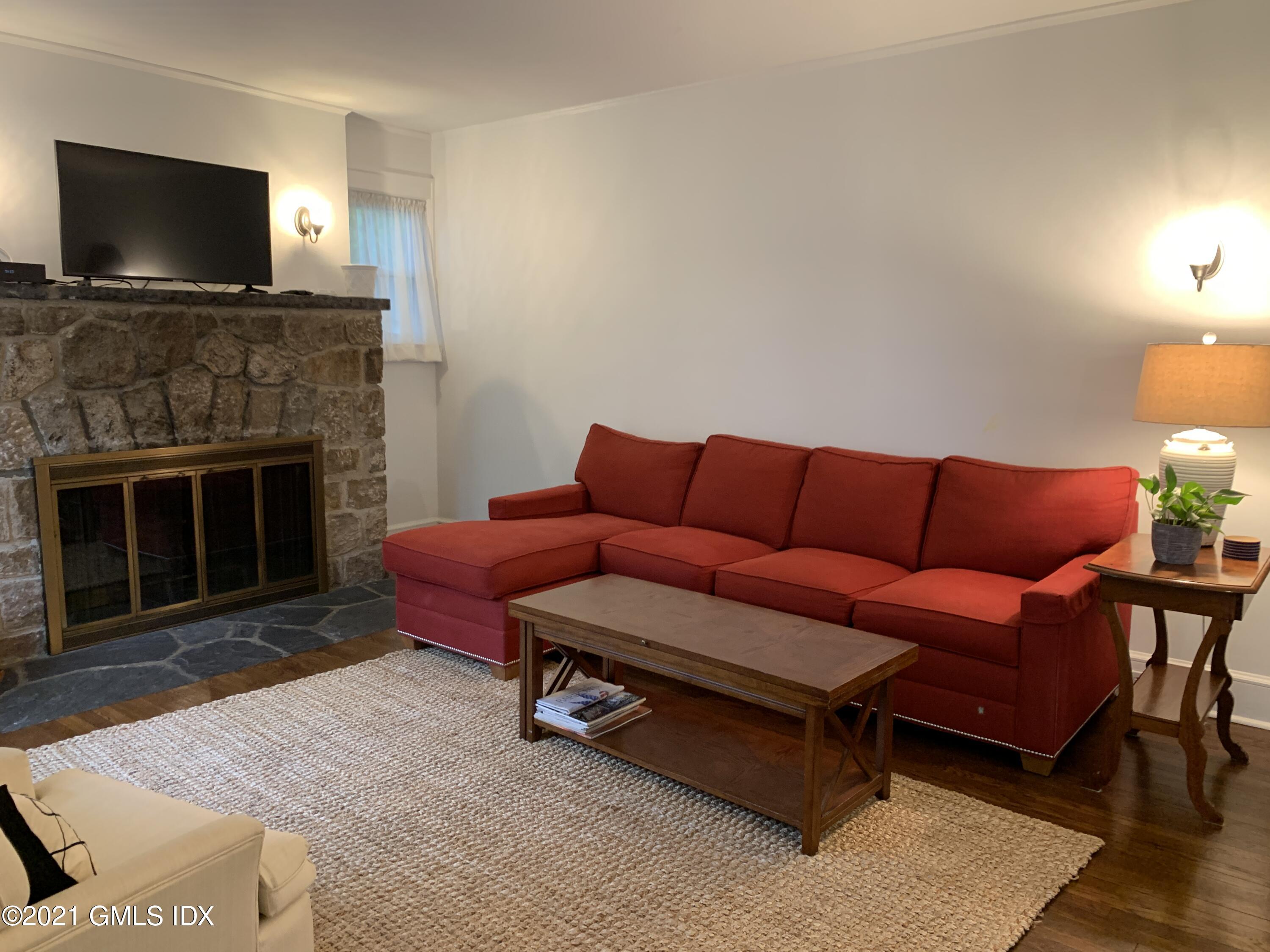 34 Sinawoy Road Cos Cob, CT 06807 - Photo 5 of 16 a living room with furniture a flat screen tv and a fireplace