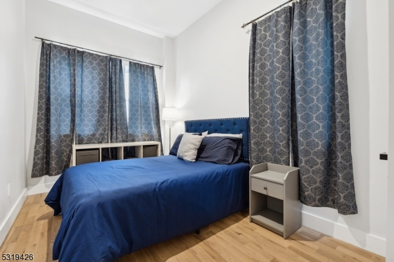 104 Fleming Avenue, Unit 201 Newark, NJ 07105 - Photo 19 of 33 a bedroom with a bed and a view of en suite bathroom