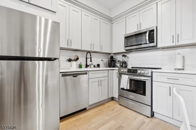 a kitchen with white cabinets and white appliances
