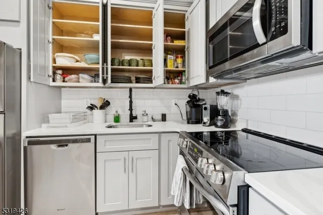 a kitchen with stainless steel appliances granite countertop a sink and cabinets