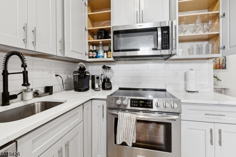 104 Fleming Avenue, Unit 201 Newark, NJ 07105 - Photo 29 of 33 a kitchen with stainless steel appliances granite countertop white cabinets a stove a sink and dishwasher