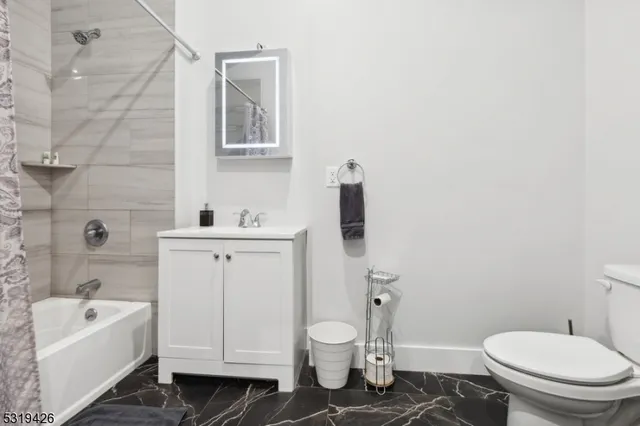 a bathroom with a granite countertop toilet a sink and bathtub