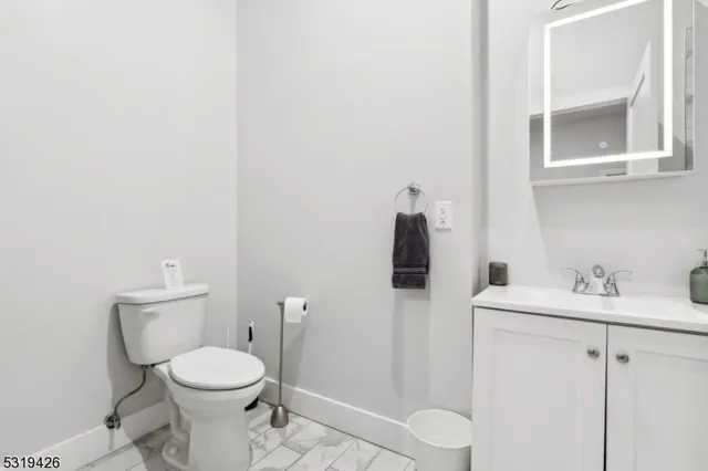 a bathroom with a toilet sink and mirror