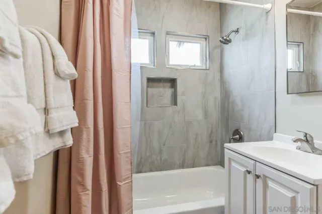 a bathroom with a sink vanity tub and shower