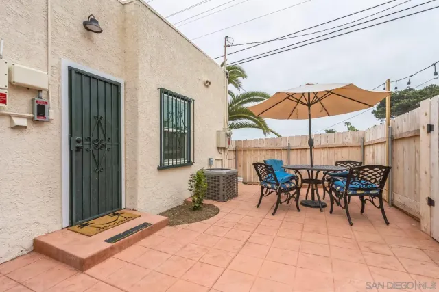 a view of a patio with a dining table and chairs under an umbrella
