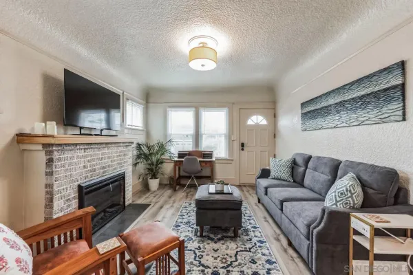 a living room with furniture a flat screen tv and a fireplace