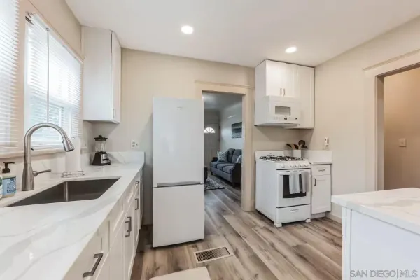 a kitchen with white cabinets sink and white appliances