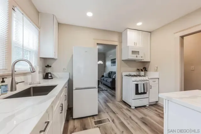 a kitchen with white cabinets sink and white appliances