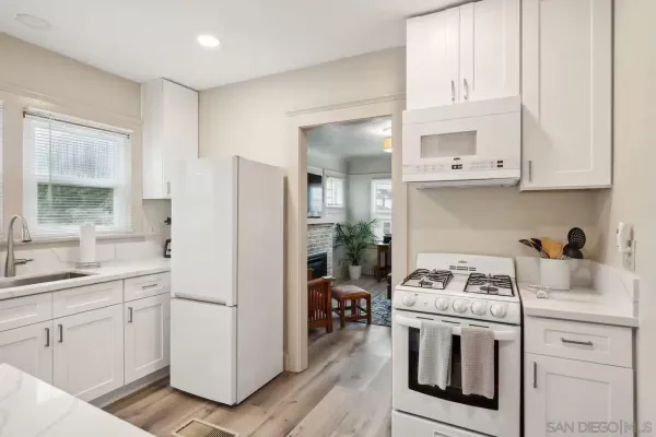 a kitchen with white cabinets and white appliances