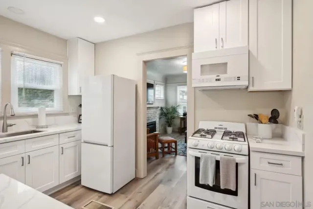 a kitchen with white cabinets and white appliances