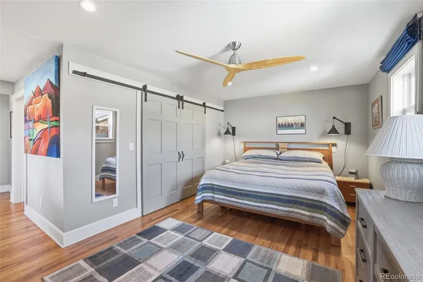 a spacious bedroom with a bed and a painting on the wall