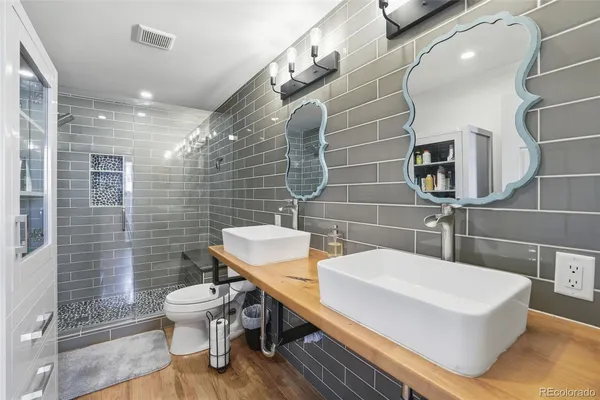a bathroom with a sink a toilet and shower