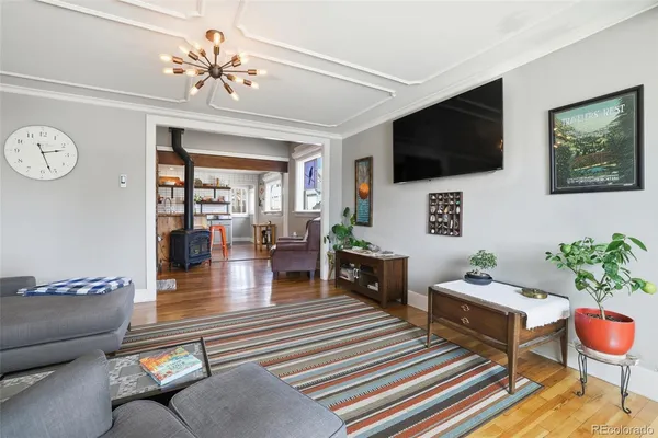 a living room with furniture a flat screen tv and a chandelier