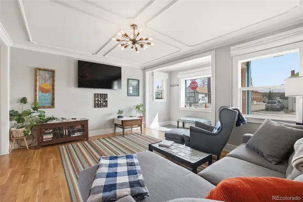 a living room with furniture a flat screen tv and a chandelier