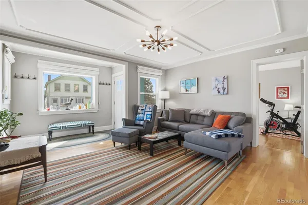 a living room with furniture and a chandelier