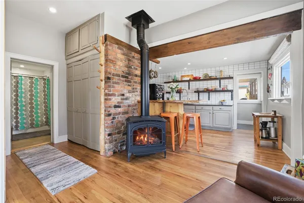 a living room with stainless steel appliances furniture a rug and a view of kitchen