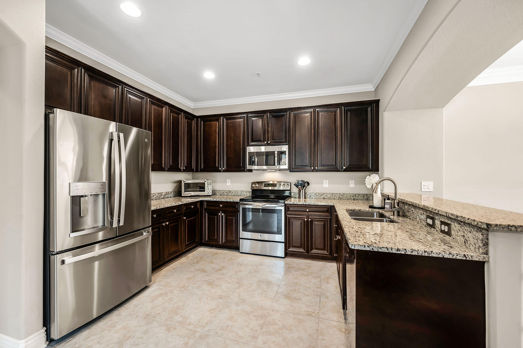 9066 Albion Lane North, Unit 5101 Naples, FL 34113 - Photo 3 of 48 a kitchen with granite countertop stainless steel appliances and wooden cabinets