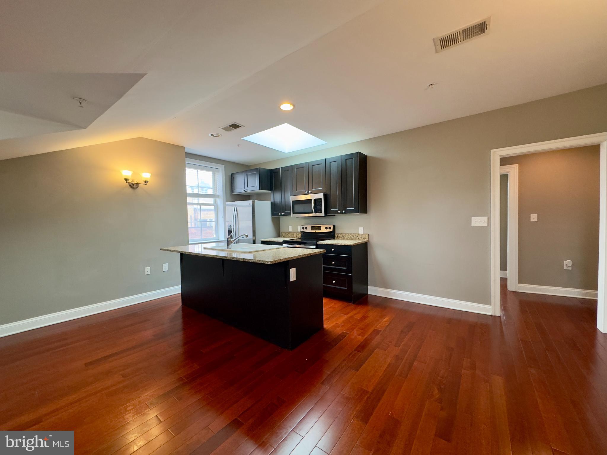 803 Cathedral Street, Unit 9 Baltimore, MD 21201 - Photo 14 of 14 a view of kitchen with wooden floor and electronic appliances
