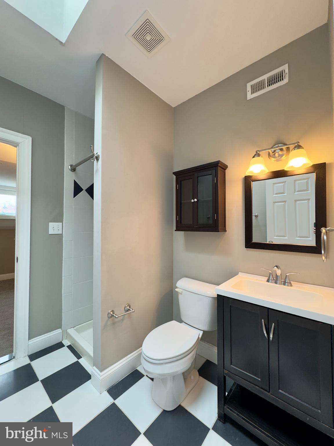 803 Cathedral Street, Unit 9 Baltimore, MD 21201 - Photo 8 of 14 a bathroom with a toilet sink and mirror