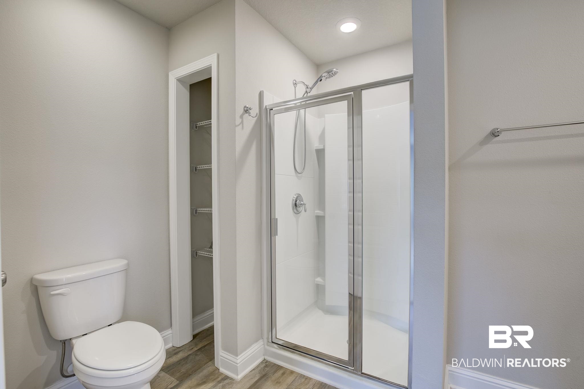 25806 Pollard Road, Unit 60 Daphne, AL 36526 - Photo 24 of 35 Bathroom featuring hardwood / wood-style floors, a shower with door, and toilet