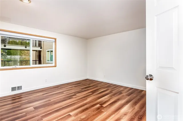 a view of empty room with wooden floor