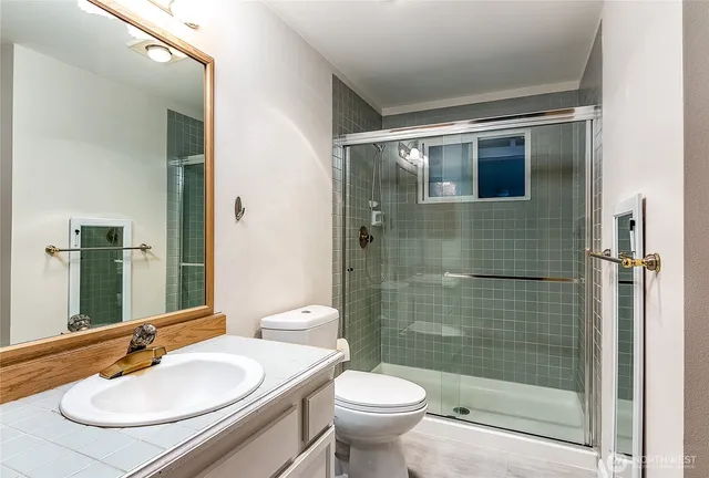a bathroom with a sink a toilet and shower