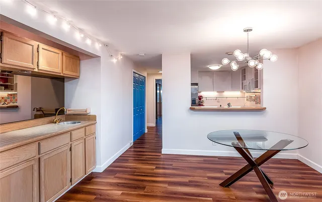 a kitchen with stainless steel appliances granite countertop a dining table chairs sink and cabinets
