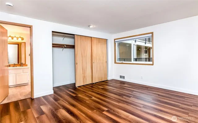 a view of empty room with wooden floor and entryway
