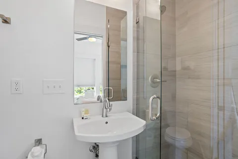 a bathroom with a sink a toilet and shower