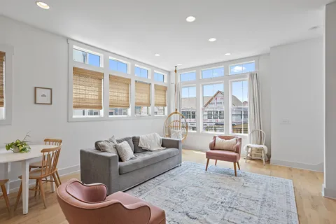 a living room with furniture and a floor to ceiling window
