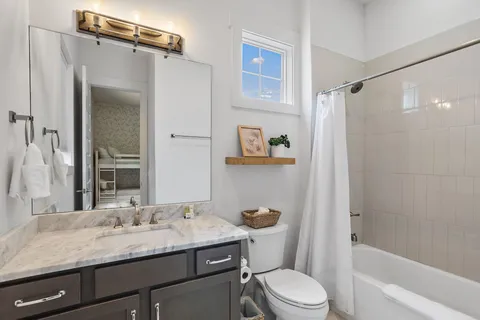 a bathroom with a granite countertop sink toilet and shower
