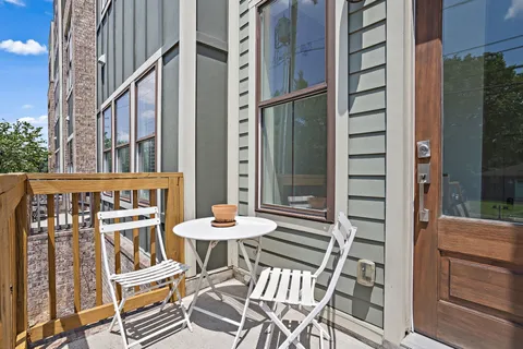 a view of a balcony with chairs and table