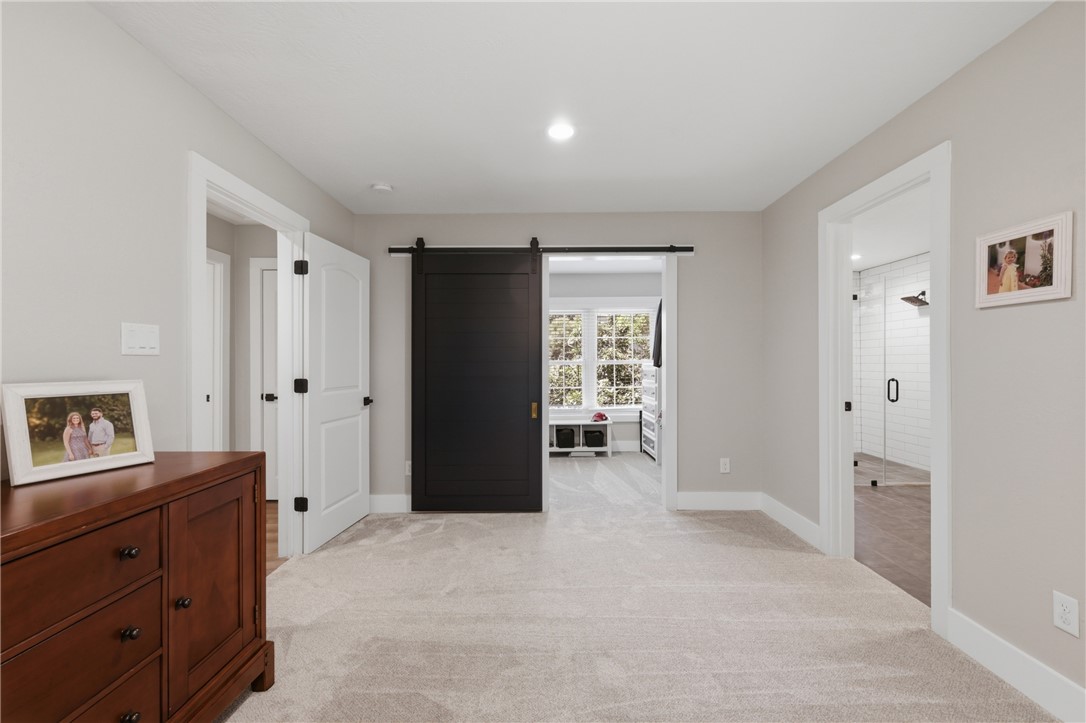 515 Crescent Drive Bryan, TX 77801 - Photo 20 of 43 Carpeted primary room featuring accented barn door, recessed lighting, and a neutral wall color