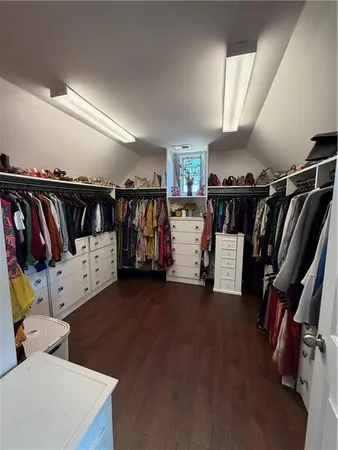 a living room with stainless steel appliances kitchen island granite countertop a couch dining table and chairs with wooden floor